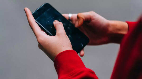 Two hands holding a phone and using both thumbs