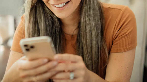 Two hands holding a phone, scrolling with one thumb